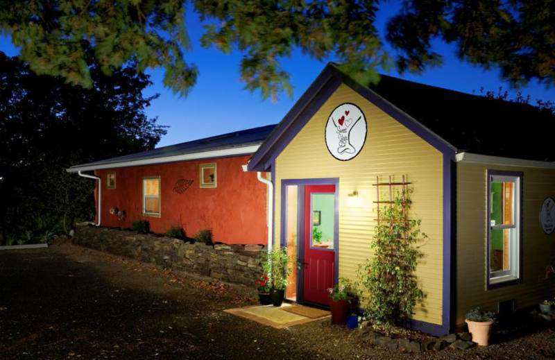 Sweet Yoga studio's brightly colored entrance and building at night